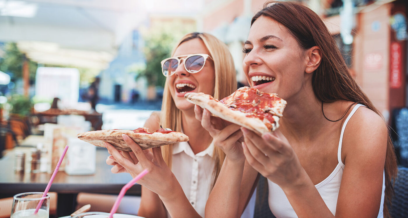Girl friends eating pizza at a local hangout