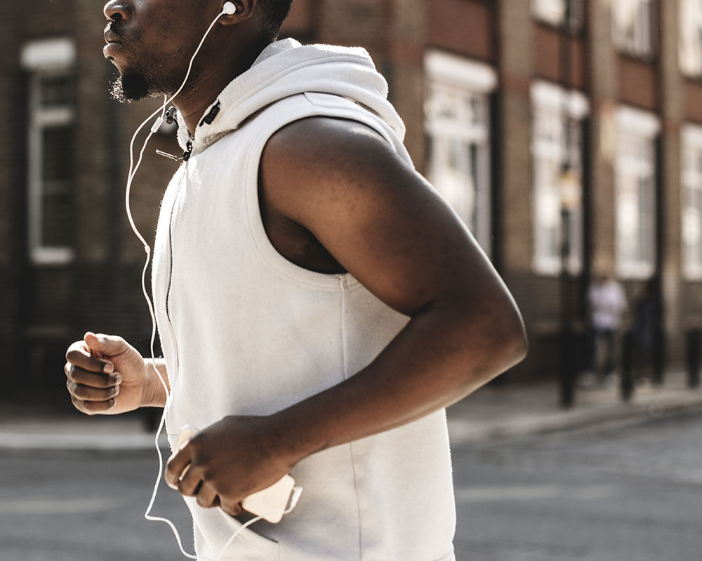 Man jogging with smartphone and headphones in the city